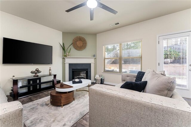 living room featuring ceiling fan and dark hardwood / wood-style flooring