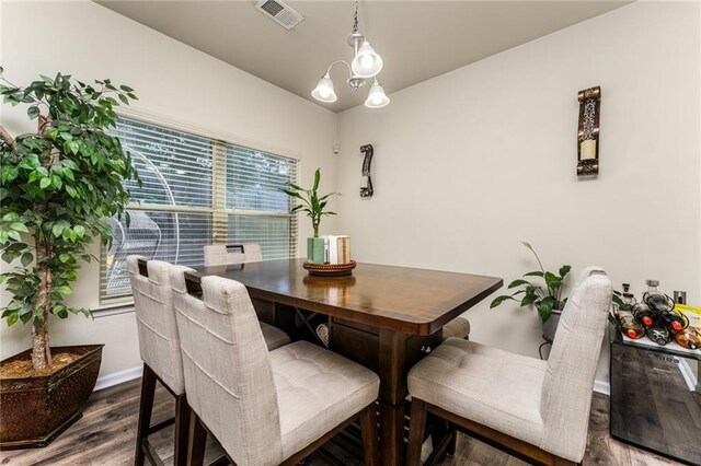 dining area with a chandelier, wood-type flooring, and a wealth of natural light