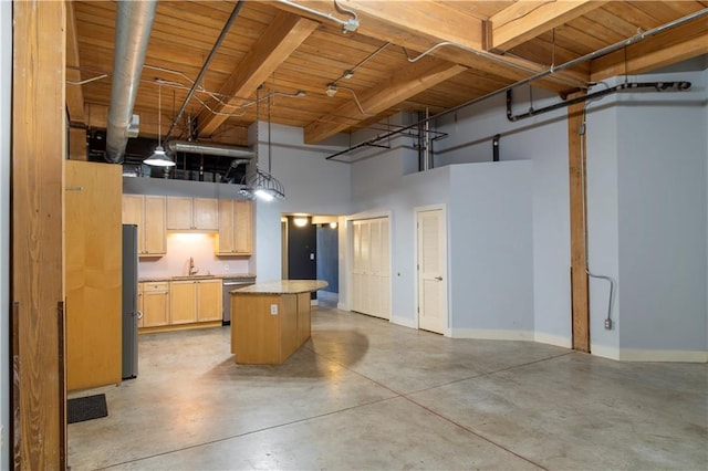 below grade area with freestanding refrigerator, baseboards, and a sink