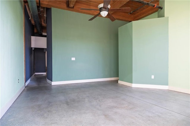 empty room with a ceiling fan, finished concrete flooring, and baseboards