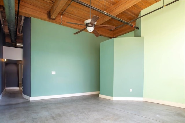 spare room featuring finished concrete floors, wood ceiling, baseboards, and a ceiling fan