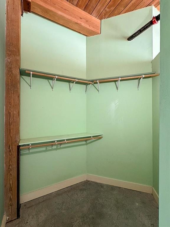 walk in closet with beam ceiling