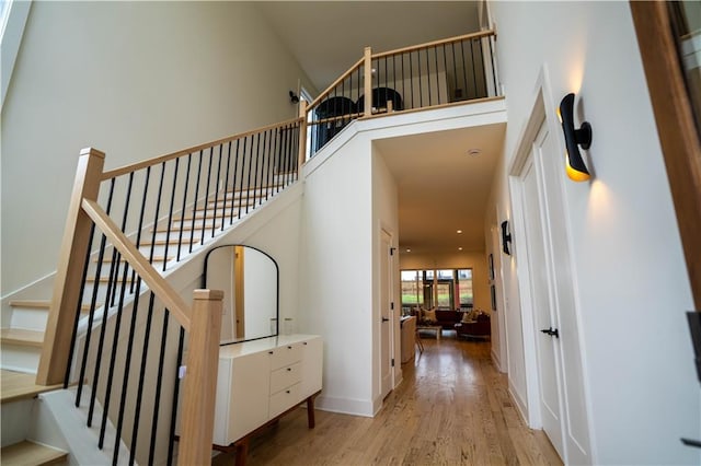 1122 Rice St NW, Atlanta, GA 30318 - stairs with wood finished floors, a high ceiling, and baseboards