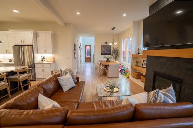 1122 Rice St NW, Atlanta, GA 30318 - living room featuring light wood finished floors, a glass covered fireplace, recessed lighting, a chandelier, and beamed ceiling