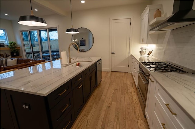 1122 Rice St NW, Atlanta, GA 30318 - kitchen featuring wall chimney exhaust hood, appliances with stainless steel finishes, a sink, white cabinets, and light wood-type flooring