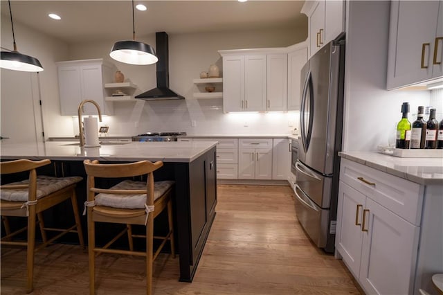 1122 Rice St NW, Atlanta, GA 30318 - kitchen with freestanding refrigerator, wall chimney exhaust hood, open shelves, light wood finished floors, and white cabinets