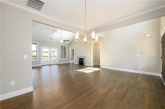 unfurnished living room with dark hardwood / wood-style flooring, ceiling fan with notable chandelier, lofted ceiling, crown molding, and french doors