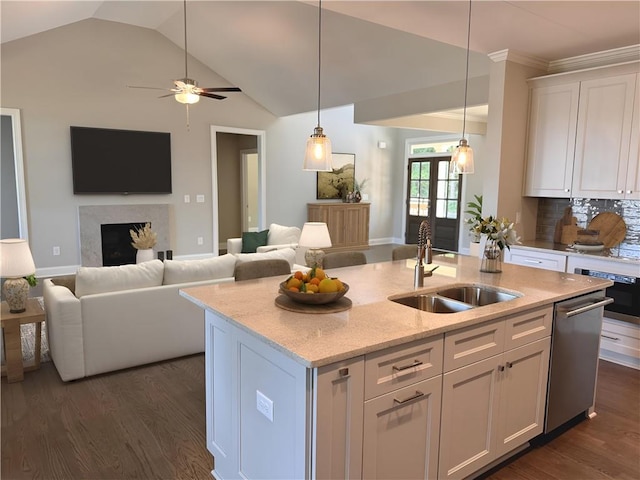 kitchen with a center island with sink, decorative light fixtures, sink, and white cabinets