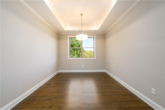 unfurnished dining area with a raised ceiling, ornamental molding, and dark hardwood / wood-style floors