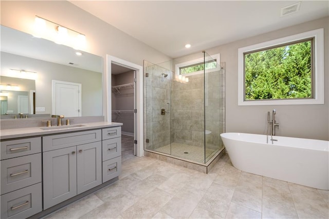 bathroom with shower with separate bathtub, tile patterned floors, and vanity