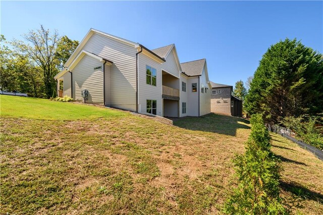 back of property with a lawn and a balcony