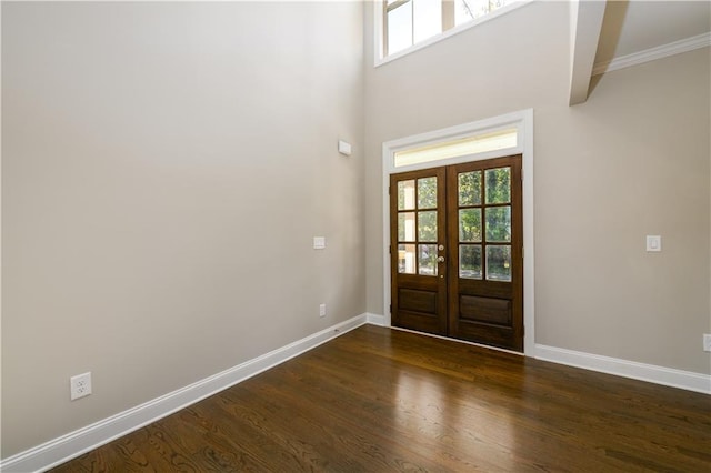 foyer entrance featuring ornamental molding, a towering ceiling, french doors, and dark hardwood / wood-style flooring