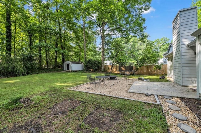 view of yard with a patio, an outdoor structure, fence, and a storage shed