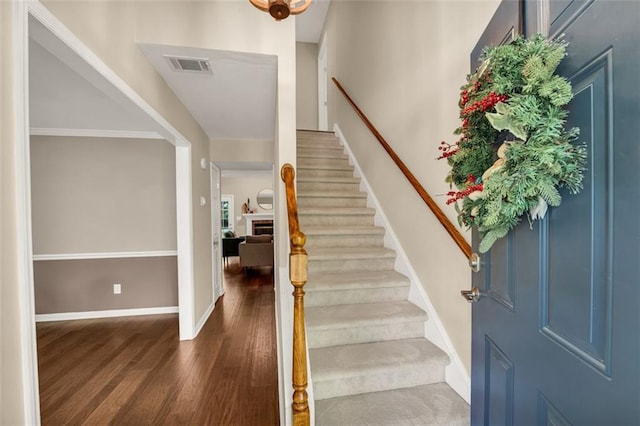 interior space featuring stairs, baseboards, visible vents, and wood finished floors