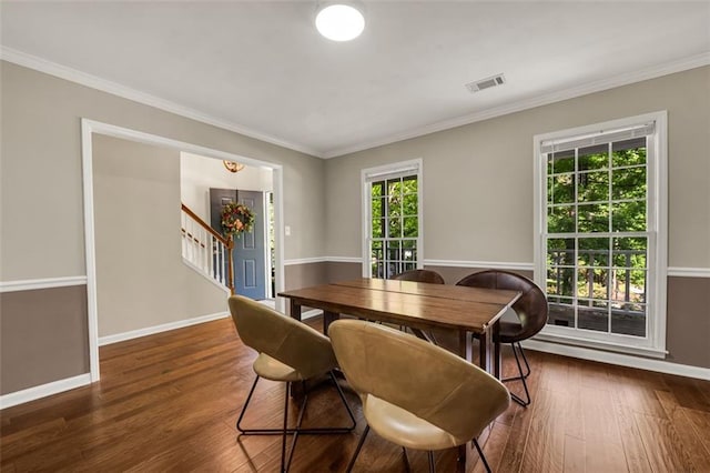 dining area featuring stairway, baseboards, crown molding, and wood finished floors