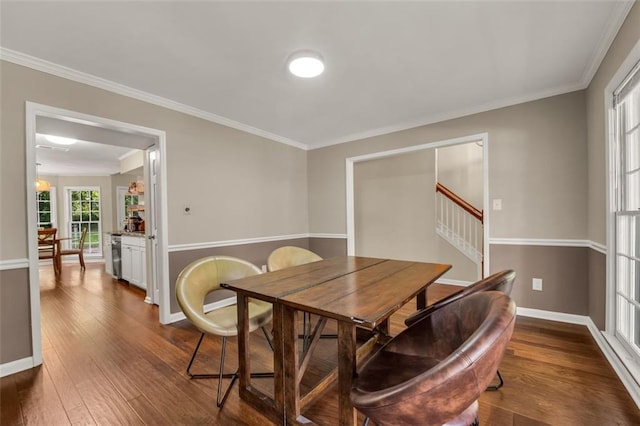 dining room featuring baseboards, ornamental molding, and dark wood-type flooring