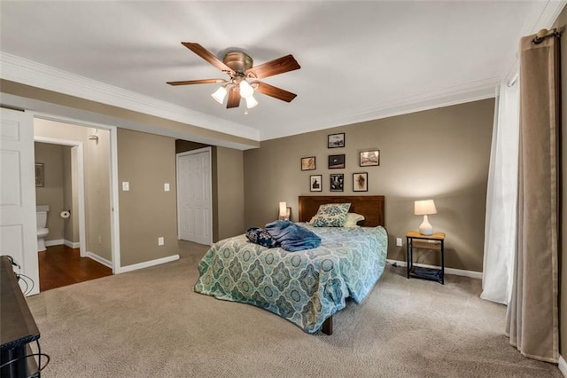 carpeted bedroom with baseboards, ornamental molding, and ensuite bath