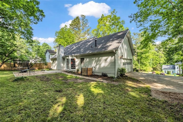 rear view of house with fence and a yard