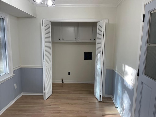 laundry area featuring crown molding, light hardwood / wood-style flooring, and an inviting chandelier