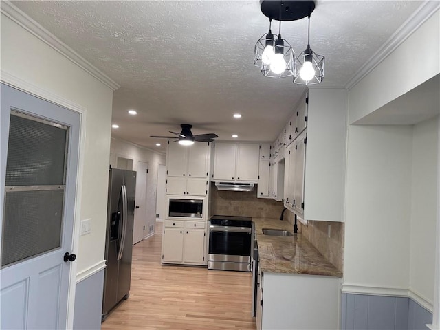 kitchen with white cabinetry, sink, backsplash, decorative light fixtures, and appliances with stainless steel finishes