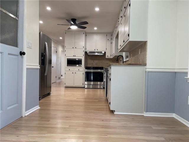 kitchen with ceiling fan, stainless steel appliances, tasteful backsplash, light hardwood / wood-style floors, and white cabinets