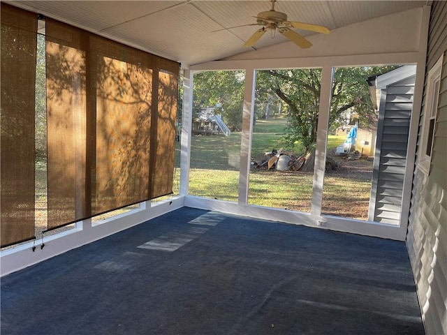 unfurnished sunroom with ceiling fan, a healthy amount of sunlight, and vaulted ceiling