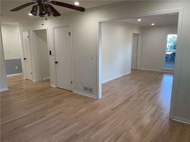 unfurnished room featuring ceiling fan, light wood-type flooring, and ornamental molding