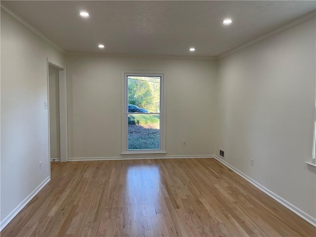 empty room featuring crown molding and light hardwood / wood-style flooring