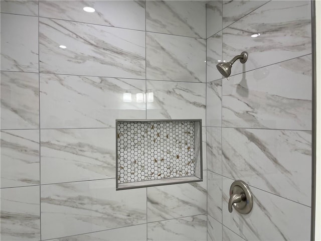 interior details featuring a tile shower