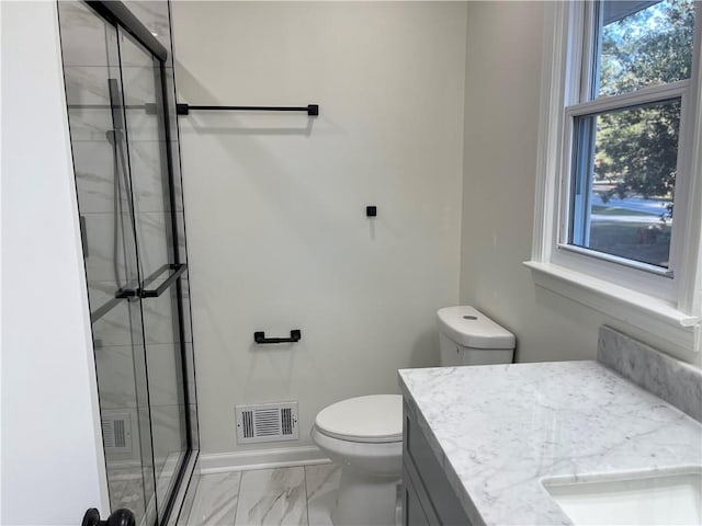 bathroom featuring vanity, toilet, and a shower with door