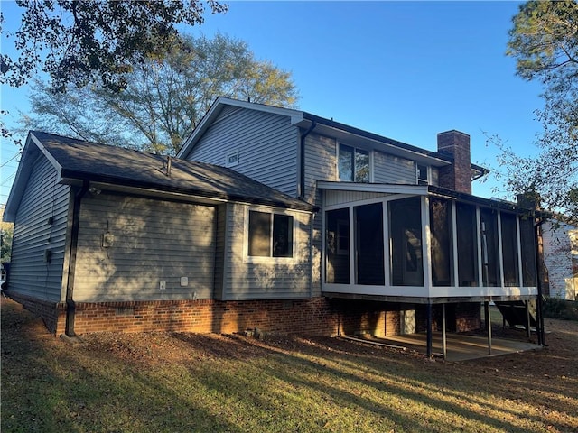 rear view of property with a yard and a sunroom