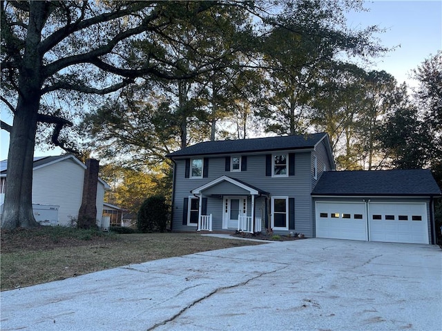 colonial inspired home featuring a porch and a garage