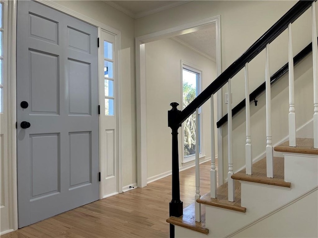 foyer entrance featuring light hardwood / wood-style floors and ornamental molding