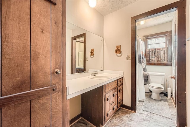 full bathroom with a textured ceiling, vanity, and toilet