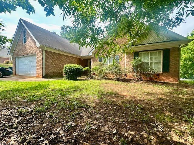 1861 Crowell Rd SW, Conyers, GA 30094 - view of front facade featuring brick siding, an attached garage, and a front yard