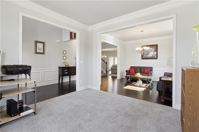 office featuring a wainscoted wall, dark colored carpet, crown molding, a chandelier, and a decorative wall