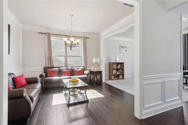 living room with ornamental molding, visible vents, dark wood finished floors, and an inviting chandelier