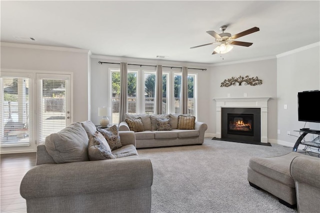 living room with crown molding, baseboards, a fireplace with flush hearth, and a healthy amount of sunlight