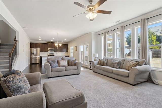 living area with visible vents, crown molding, stairway, and baseboards