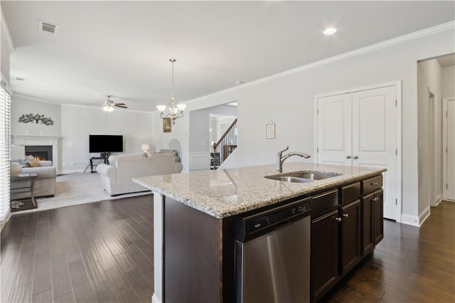 kitchen featuring a warm lit fireplace, open floor plan, a kitchen island with sink, stainless steel dishwasher, and a sink