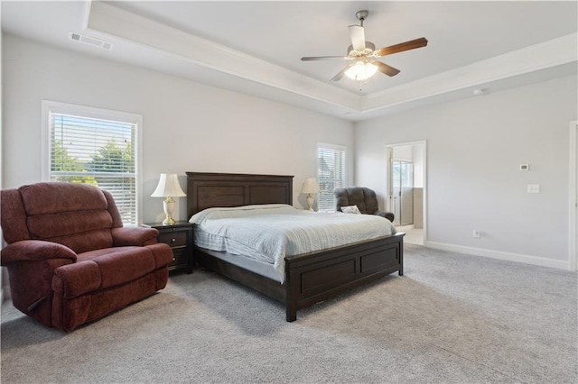 bedroom featuring a raised ceiling, multiple windows, and baseboards