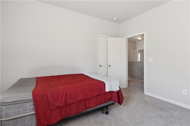 bedroom featuring light colored carpet and baseboards