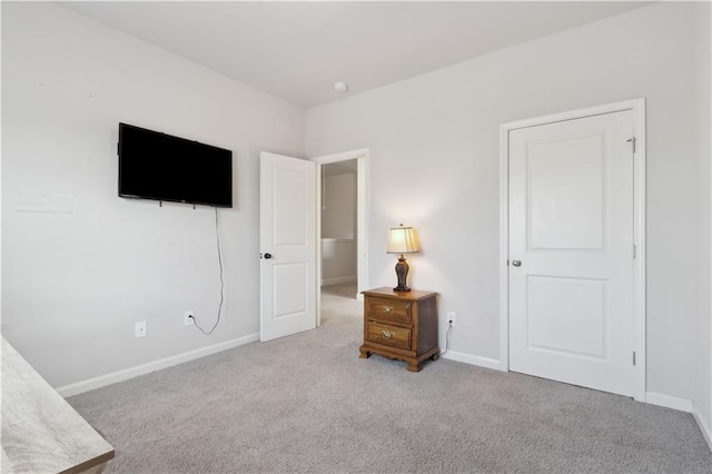 bedroom with baseboards and light colored carpet