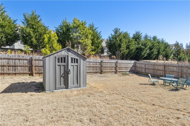 view of yard with a storage shed, an outbuilding, and a fenced backyard