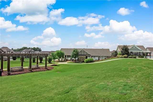 view of property's community featuring a yard, a residential view, and a pergola