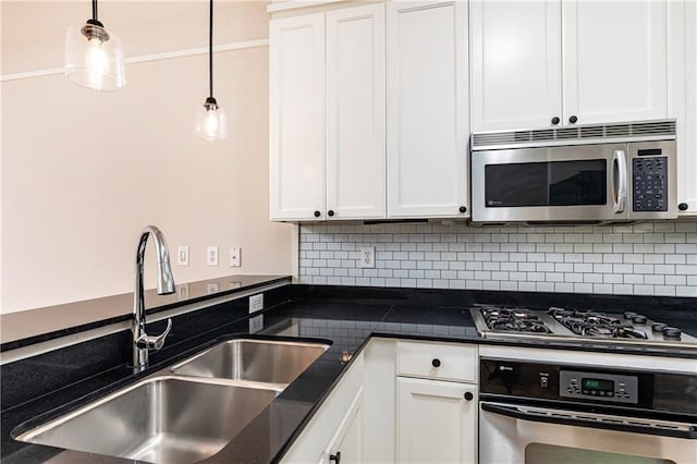 kitchen featuring sink, white cabinets, stainless steel appliances, and decorative light fixtures