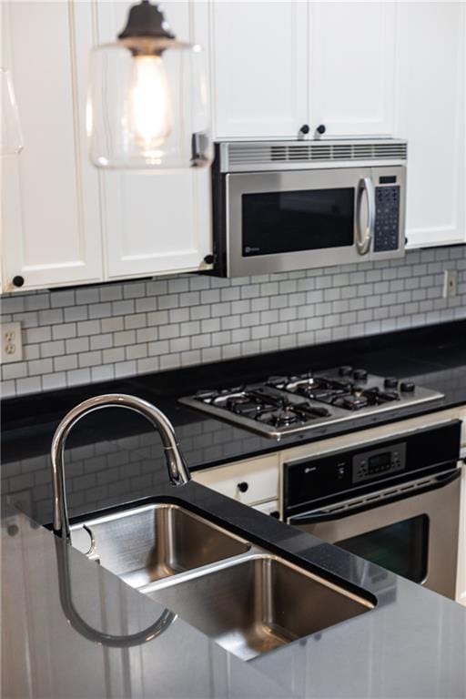 kitchen with white cabinets, sink, stainless steel appliances, and tasteful backsplash