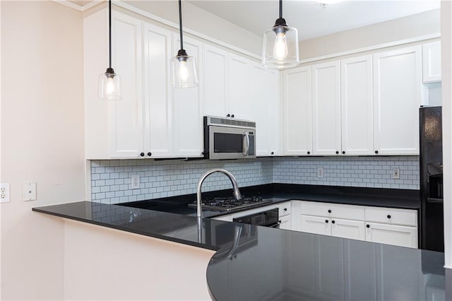 kitchen with white cabinets, pendant lighting, kitchen peninsula, and appliances with stainless steel finishes