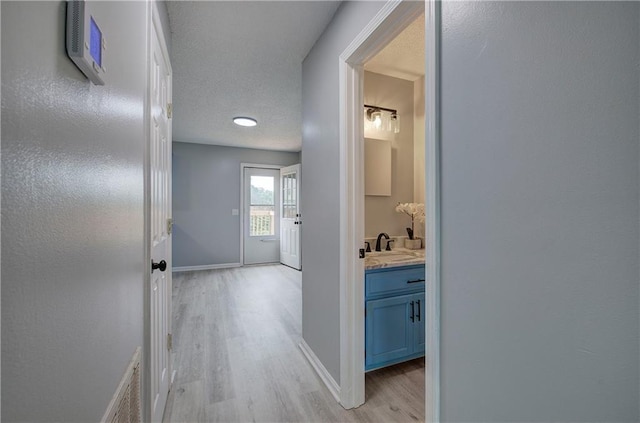 128 Evergreen Trl Unit 4, Cartersville, GA 30121 - hallway with light wood-style floors, a sink, baseboards, and a textured ceiling