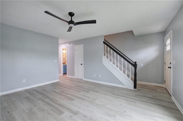128 Evergreen Trl Unit 4, Cartersville, GA 30121 - unfurnished living room with a ceiling fan, stairs, light wood-type flooring, baseboards, and a textured ceiling